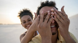 thumbnail image of woman covering her boyfriend's eyes with her hands