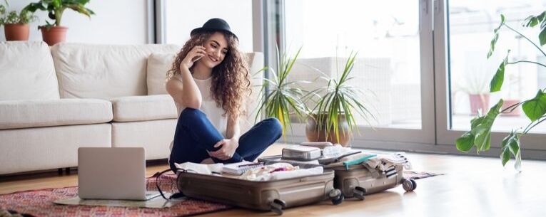 Allianz - young woman on phone packing for a trip