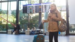 woman standing in airport with phone