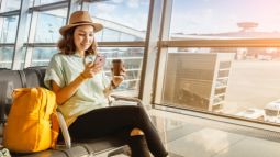 woman using phone while waiting in airport