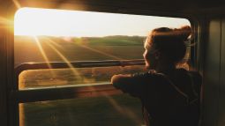 woman looking out window on train